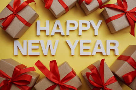 Happy New Year alphabet letters with gift boxes on yellow backgroundの写真素材