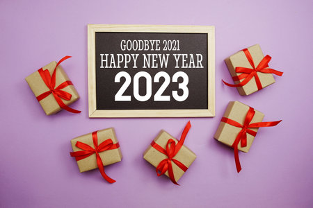 Happy New Year 2023 typography text with gift box on purple backgroundの写真素材