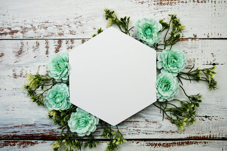 Frame of flowers with paper card for text on wooden backgroundの写真素材
