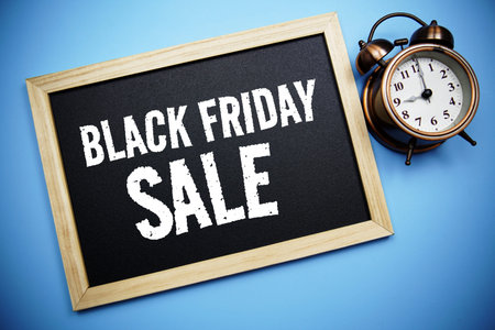 Black Friday Sale text message on Blackboard and alarm clock on blue backgroundの写真素材