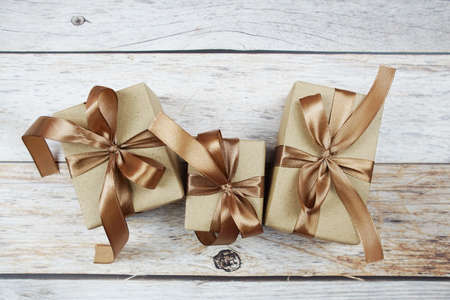 Gift boxes with gold ribbon on wooden backgroundの写真素材