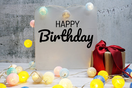 Happy Birthday text message with LED cotton ball decoration on wooden backgroundの写真素材