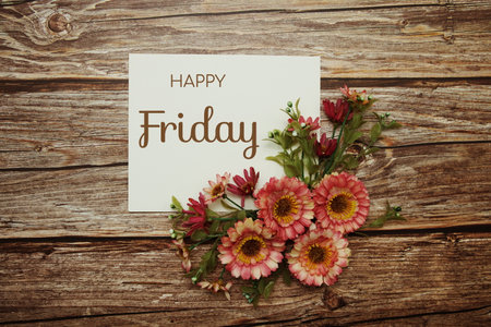 Happy Friday typography text with flowers on wooden backgroundの写真素材