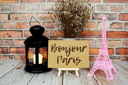 Bonjour Paris text message write on paper card with pink Eiffel tower souvenir and flower bloomingの写真素材