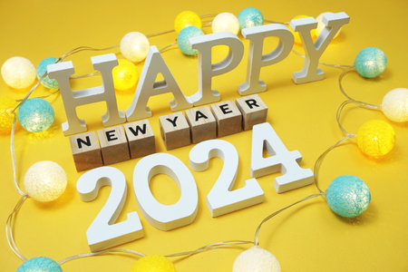Happy New Year 2024 alphabet letter with LED cotton balls on yellow backgroundの写真素材