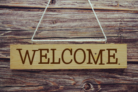 Welcome sign with rope hanging on wooden backgroundの写真素材