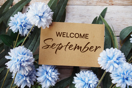 Welcome September text message with flower decoration on wooden backgroundの写真素材