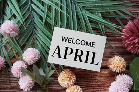 Welcome April text message with flower decoration on wooden backgroundの写真素材