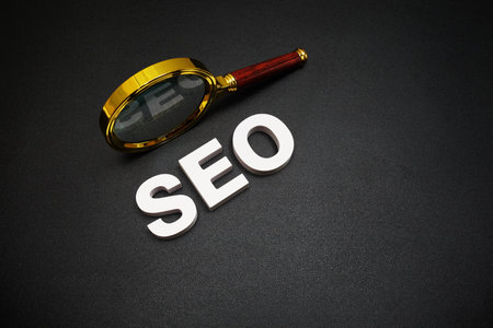 SEO (search engine optimization) text message with magnifying glass on black backgroundの写真素材