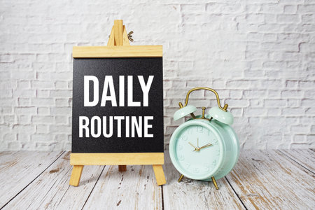 Daily Routine text message and alarm clock on wooden backgroundの写真素材