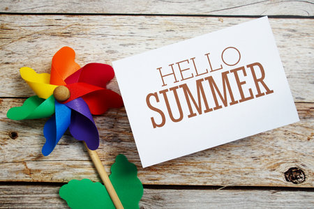Hello Summer text message with windmill on wooden backgroundの写真素材