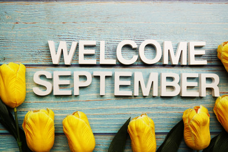 Welcome September alphabet letters with tulip flower on wooden backgroundの写真素材