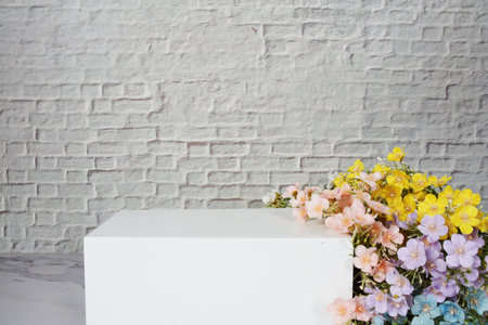 White squre podium with flower decoration for product display with white brick wall backgroundの写真素材