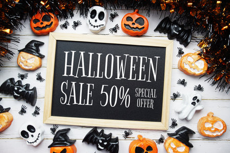 Halloween sale 50% text message write on blackboard with Halloween decoration on wooden backgroundの写真素材
