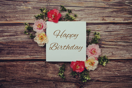 Happy Birthday typography text decorate with flower on wooden backgroundの写真素材