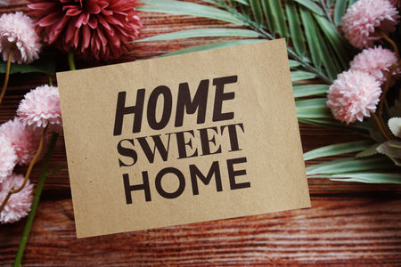 Home Sweet Home text message with flower decoration on wooden background