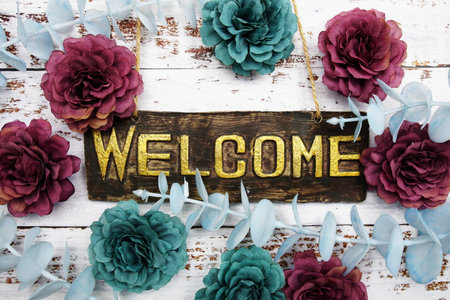 Welcome Sign with flowers frame decorate on wooden backgroundの写真素材