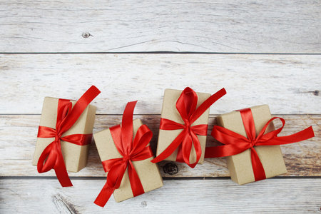 Gift boxes with red ribbon on wooden background