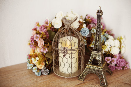 Home decor Eiffel tower, LED candle light and artificial flower on wooden shelve backgroundの写真素材