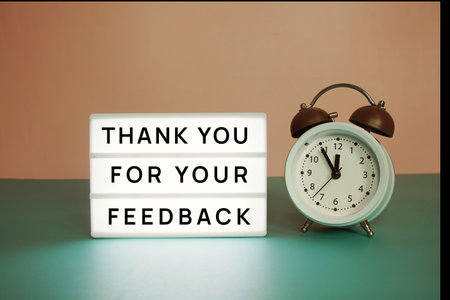 Thank you for your feedback text message on paper card with wooden easel and alarm clockの写真素材