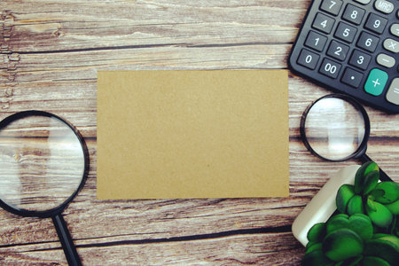 Workplace with magnifying glass and calculator top view on wooden background, Concept business and financeの写真素材