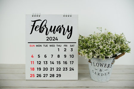 February 2024 monthly calendar with vintage alarm clock on wooden backgroundの写真素材