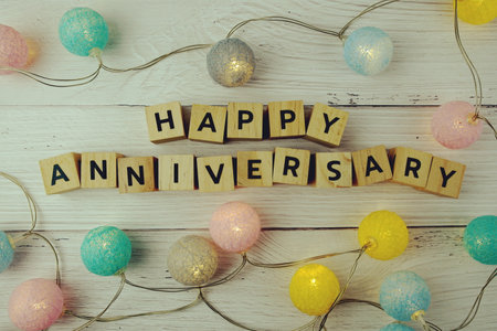 Happy Anniversary alphabet letters with LED cotton balls decoration on wooden backgroundの写真素材