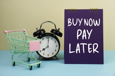 Buy Now Pay Later text message with trolley cart and alarm clock for business and commercial concepts backgroundの写真素材