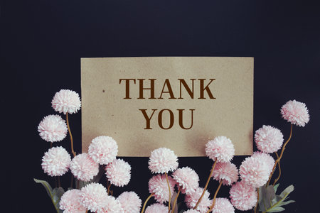 Thank you text message with flower decoration on wooden backgroundの写真素材