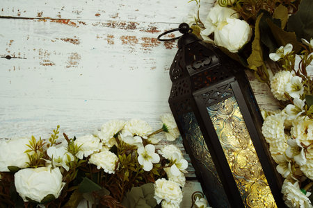 Black Moroccan Arabic lantern with flower on white table background