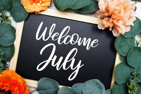 Welcome July text message with flower decoration on marble backgroundの写真素材