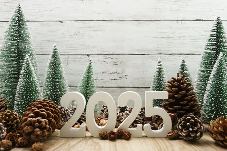 Happy New year 2025 decoration with Christmas tree and pine cones on wooden backgroundの写真素材