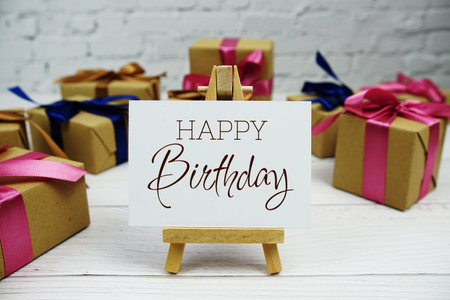 Happy Birthday text on paper card with gift box present on wooden backgroundの写真素材