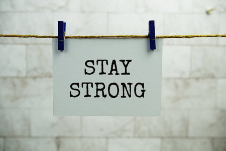 Stay Strong text on paper card hanging on the wall with Clothespinsの写真素材