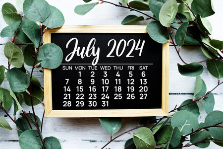 July 2024 monthly calendar monthly calendar on wooden chalkboard background for planning and managementの写真素材