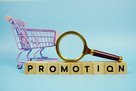 Promotion with wooden blocks alphabet letters and Magnifying glass on blue backgroundの写真素材