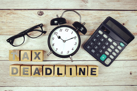 Tax Deadline with alarm clock top view on wooden backgroundの写真素材