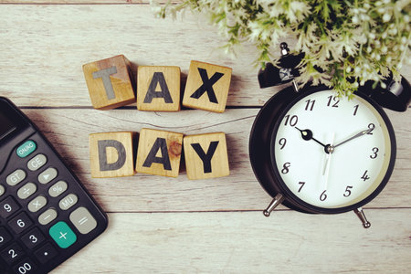 Tax Day with alarm clock with space copy on wooden backgroundの写真素材