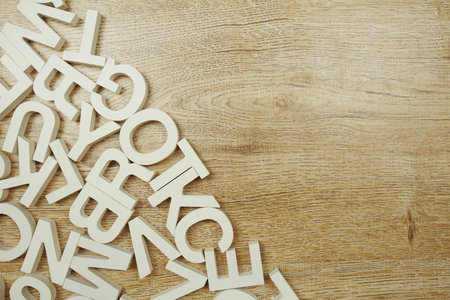 Top view random wooden alphabet letters on wooden background
