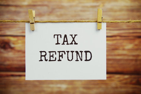 Tax Refund text on paper card hanging on the wall with Clothespinsの写真素材