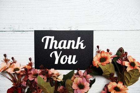 Thank You typography text with flowers blooming decorated on wooden backgroundの写真素材