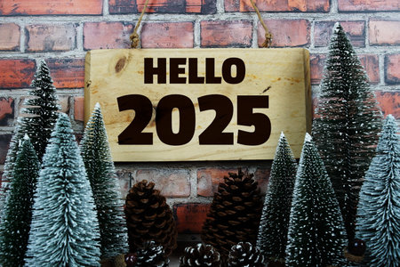 Happy New Year 2025 with Christmas tree and pine cone decoration on old brick wall and wooden backgroundの写真素材