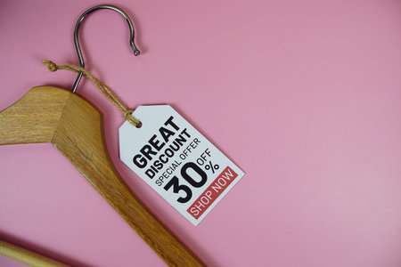 Great Discount sale up to 30% off on price tag with wooden clothes hanger top view on pink...