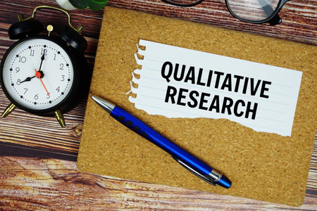 Qualitative Research text written on paper torn with alarm clock top viewの写真素材