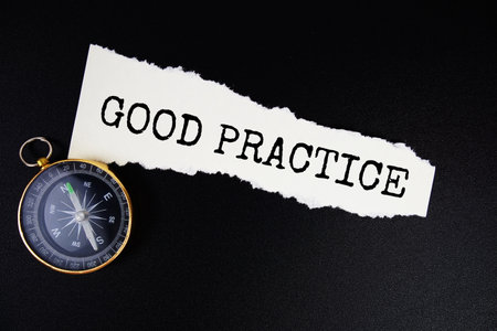 Good Practice text written on paper torn with compass top view on black backgroundの写真素材