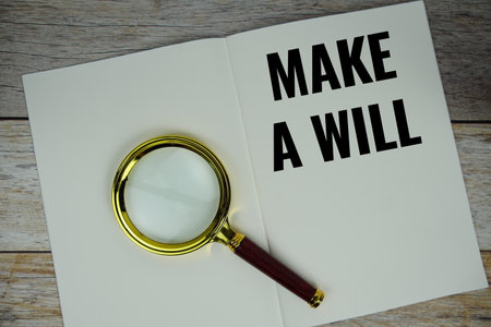 Make a will text on note page with magnifying glass top view on wooden backgroundの写真素材