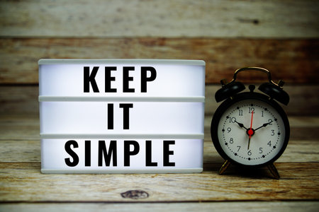Keep it Simple text on LED lightbox with alarm clock on wooden background, Inspiring Creative Motivation Quoteの写真素材