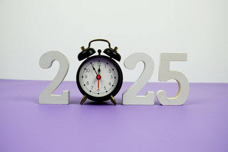 Happy new year 2025 and alarm clock on purple backgroundの写真素材