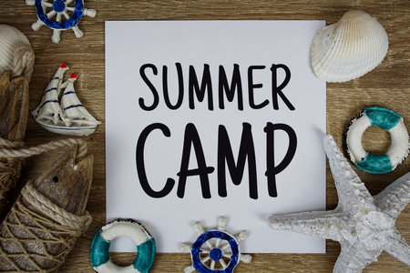 Summer Camp text on paper card with marine items decorative top view on wooden backgroundの写真素材