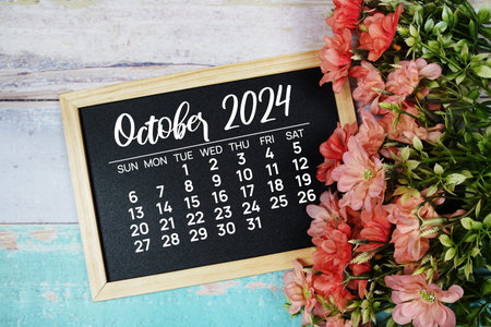 October 2024 monthly calendar with flower bouquet decoration on wooden background